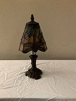 Front view of Tiffany-style stained glass table lamp with dragonfly motif showing colorful stained glass shade and metal base.