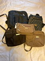 All five travel bags arranged together showing various sizes, colors and zippered compartments.