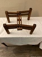 Front view of wooden foldable stand showing adjustable sliding joints