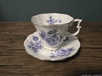 Side view of the vintage Royal Albert teacup and saucer set showing the blue floral design and gold trim on fine bone china.