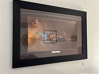 Full view of the framed print showing the black wooden frame, matte brown border, and airplane flight image.