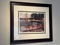 Full view of framed Tom Thomson print showing canoe and lake scene with a dark wooden frame.