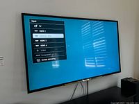 Television powered on displaying input menu with HDMI 1-4, Video, Component, Screen Mirroring