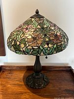 Front view of lamp on wooden surface, showing complete shade and base