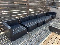 Six modular black wicker seating sections arranged side by side on rooftop deck