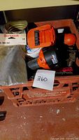 Photo of Black & Decker cordless drill with battery and various hardware pieces packed in a crate.