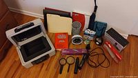 Photo of all items including Sentry Safe, staplers, phone, clock, book, magnifiers, folders, desk organizers, and office supply boxes.