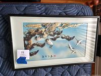 Framed 3D Asian artwork showing cranes flying and perched on tree branches, with mother of pearl inlay and mixed media, inside black frame with white mat.