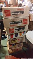Stack of boxed Ball Regular Pint Mason Jars and Kerr Mason Jars for home canning and freezing.