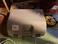 Closed gray Ryobi branded plastic carrying case for circular saw and accessories