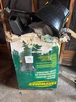 Exterior view of heavily worn cardboard box marked Yardworks, containing the garden shredder and some accessories inside.