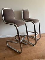 Both chrome cantilever bar stools side view showing overall design and upholstery