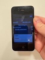 Front of black iPhone showing multilingual setup screen