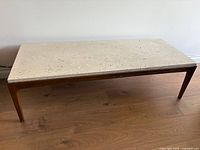 Full view of Lane travertine-top coffee table on wood floor