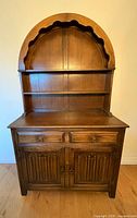 Full front view of wood hutch showing arched top shelves, drawers, and cabinet doors