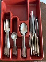 Full set in red drawer tray showing forks, teaspoons, tablespoons, knives