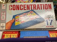 Closed box showing the Concentration game title and packaging artwork showing game with puzzle manager and player scoreboards