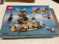 Box top rear view showing the building scene and minifigures in play with small insets of details and features.