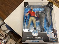 Front view of McFarlane Multiverse Peacemaker figure in sealed packaging showing figure and accessories.