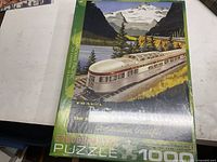 Photo of the front of the sealed puzzle box with image of Canadian Pacific train in a natural mountainous setting.