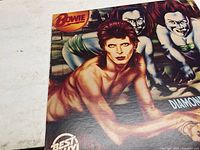 Front cover of the David Bowie Diamond Dogs album showing detailed artwork and Bowie in semi-nude pose.