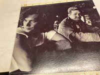 Front cover of John Cougar Mellencamp's Lonesome Jubilee record showing a black and white photo of two men.