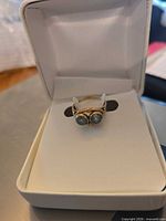 Ring in presentation box showing twin blue stones and gold band