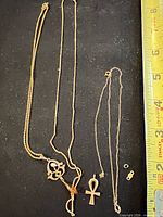 Entire necklace laid out with detached clasp pieces and measuring tape for scale