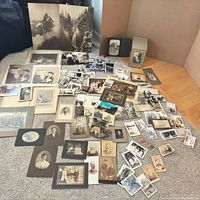 Overview of entire assortment spread on floor showing variety of photos and postcards