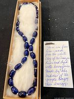 Full view of necklace in box with descriptive note