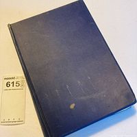 Front cover of blue cloth hardcover showing stain and wear