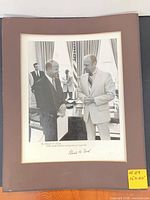 Front view of framed and matted photograph with visible inscription and signature