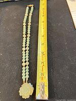 Full necklace beside ruler showing ~16 in length, jade beads and pendant visible