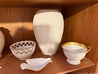 Four Lenox porcelain pieces on shelf: vase, heart bowl, compote, shell dish