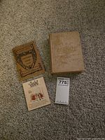 Front view of both books and greeting card on carpet