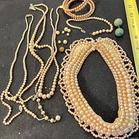 Full lot showing necklaces, bracelet, earrings, loose beads on black background