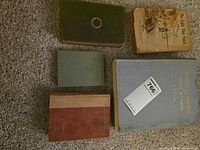 Five books arranged covers up on carpet