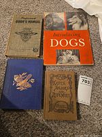 Four of the five books laid out: Professional Guide's Manual, Introducing Dogs, The Boys & Girls Illustrated Bird Book, Knots, Splices and Ropework