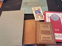 All six volumes laid out for overview: two green cloth hardcovers, brown Tad and His Father, gilt Abe Lincoln and Nancy Hanks, red Our Great Commander, small Book of Presidents pamphlet
