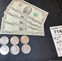 Overview of four $2 bills and six half dollars