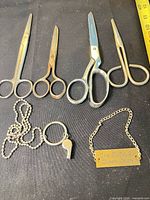 Group shot of all items: four scissors, keyring with whistle, Queen Mary tag