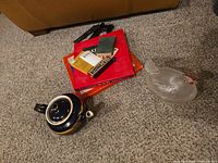 Group shot showing teapot, boxed games, playing cards, harmonica parts, glass bird dish