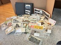Lot overview showing albums, sleeved postcards, loose cards and blotters spread on floor