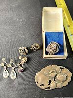 Group view of ring in box, two earring pairs, and brooch
