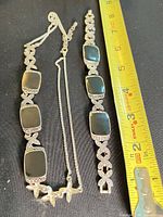 Necklace and bracelet laid flat with measuring tape