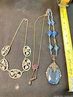 Overview of three necklaces laid out showing relative size and design details