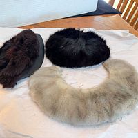 Overview of two fur hats and fur collar on table