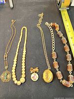 Group shot showing all five jewelry items laid out for scale