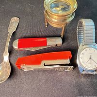 Group shot of watch, knife, magnifier, stapler and spoon