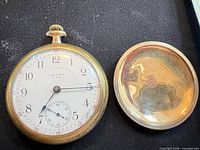 Front view showing dial, hands, and open case back cover